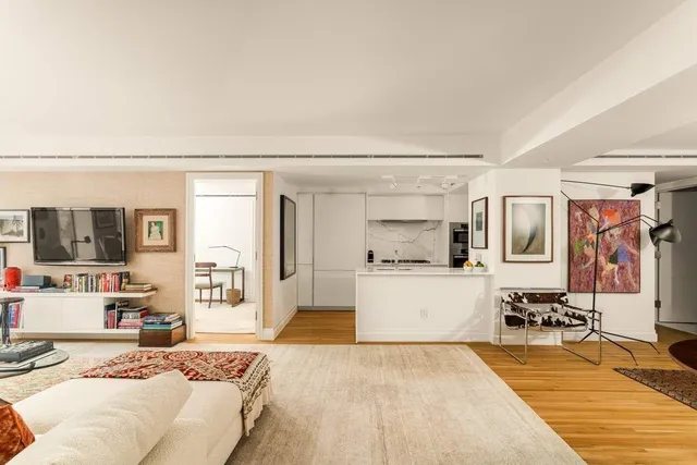 a living room with stainless steel appliances furniture and a kitchen view