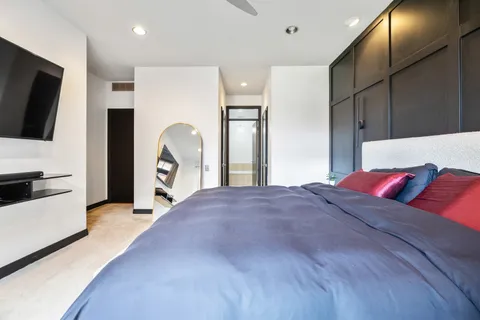 a living room with a bed furniture and a flat screen tv