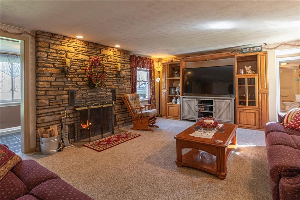 264 Baird Road Edinburg, PA 16116 - Photo 6 of 23 a living room with furniture a flat screen tv and a fireplace