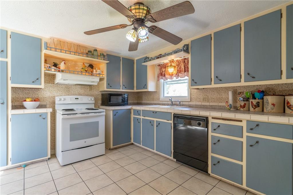 264 Baird Road Edinburg, PA 16116 - Photo 7 of 23 a kitchen with a stove sink and cabinets