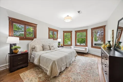 a bedroom with a bed and large windows