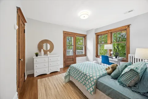a bedroom with a bed and wooden floor