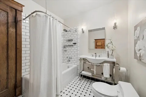 a bathroom with a sink a toilet a mirror and shower