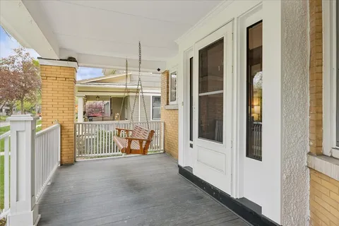 a view of a balcony with furniture and floor to ceiling window