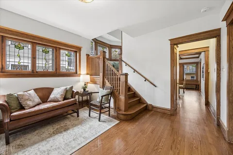 a living room with furniture and a dining table with wooden floor