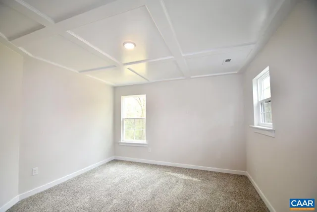 an empty room with windows and chandelier fan