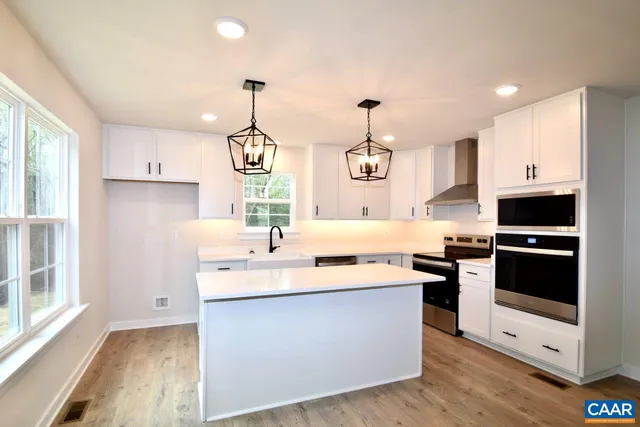 a kitchen with stainless steel appliances granite countertop a sink a stove and a refrigerator