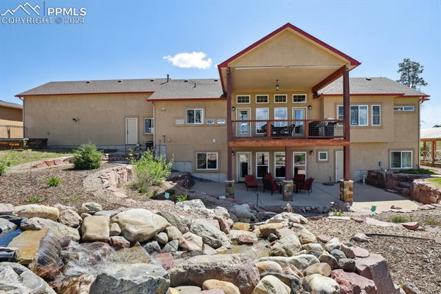 12810 Holmes Road Colorado Springs, CO 80908 - Photo 37 of 45 Rear view of property featuring a patio area and a balcony