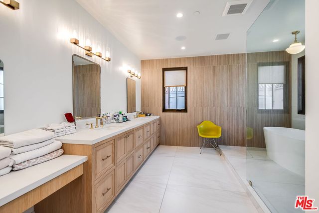a bathroom with a tub a sink and mirror