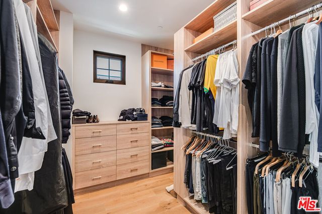 a view of walk in closet with clothes