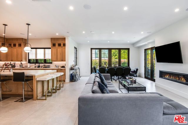 a living room with stainless steel appliances kitchen island granite countertop a stove and a large window