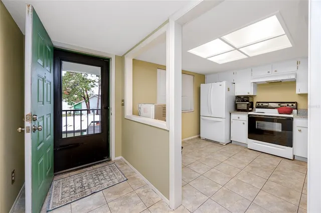 a kitchen with granite countertop a refrigerator and a stove top oven
