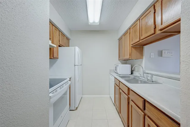 a kitchen with stainless steel appliances granite countertop a sink and a refrigerator