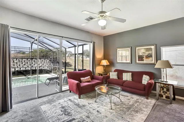 a living room with furniture a lamp and a floor to ceiling window