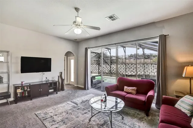 a living room with furniture a flat screen tv and a large window