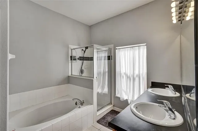 a bathroom with a tub sink and mirror