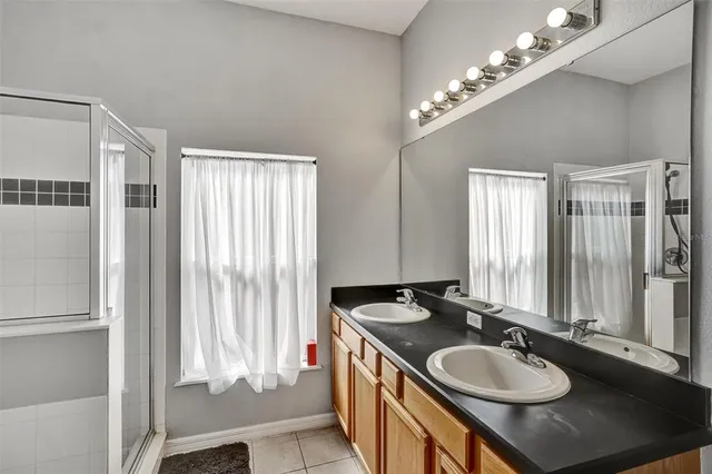 a bathroom with a granite countertop sink a large mirror and a shower