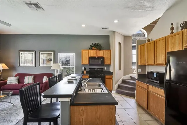 a living room with furniture a flat screen tv and kitchen view
