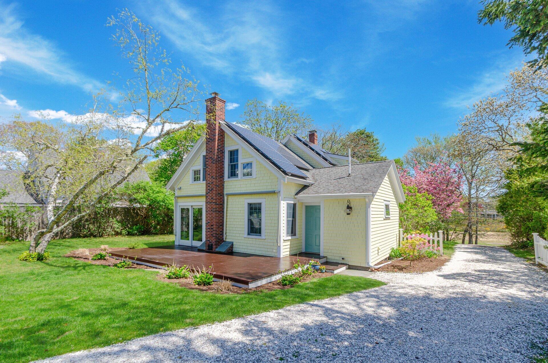 1089 Main Street Cotuit, MA 02635 - Photo 3 of 41 a front view of a house with a yard and potted plants