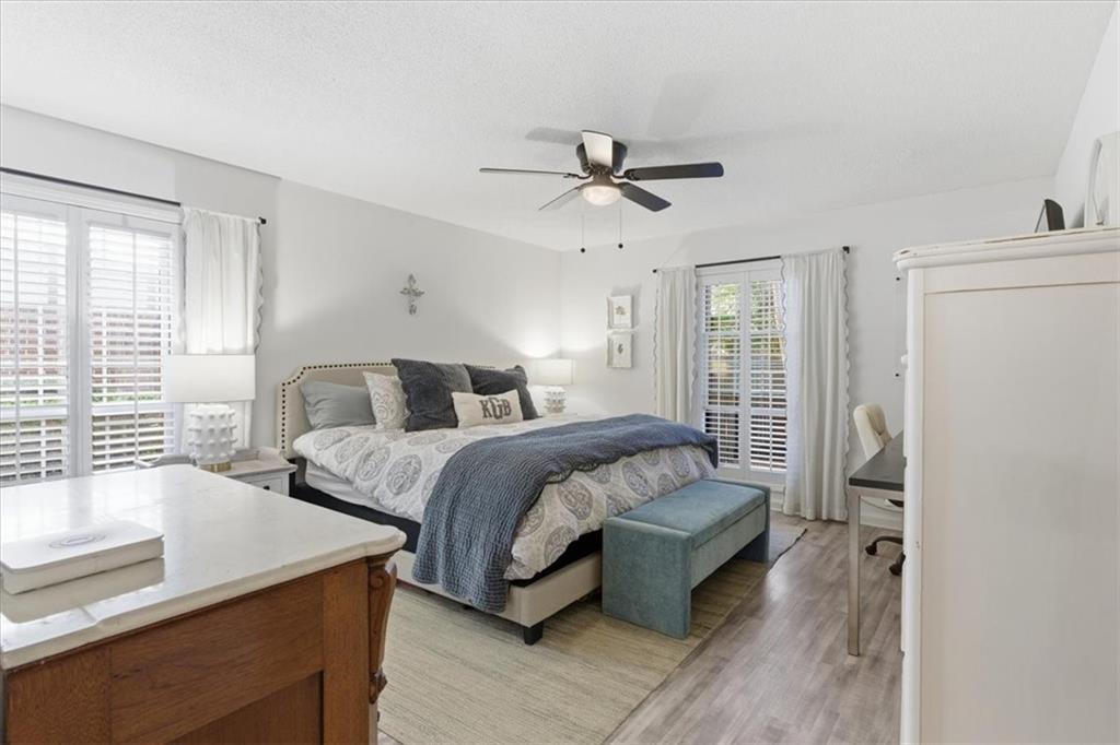 6851 Roswell Road, Unit J14 Sandy Springs, GA 30328 - Photo 11 of 41 a spacious bedroom with a bed and wooden floor