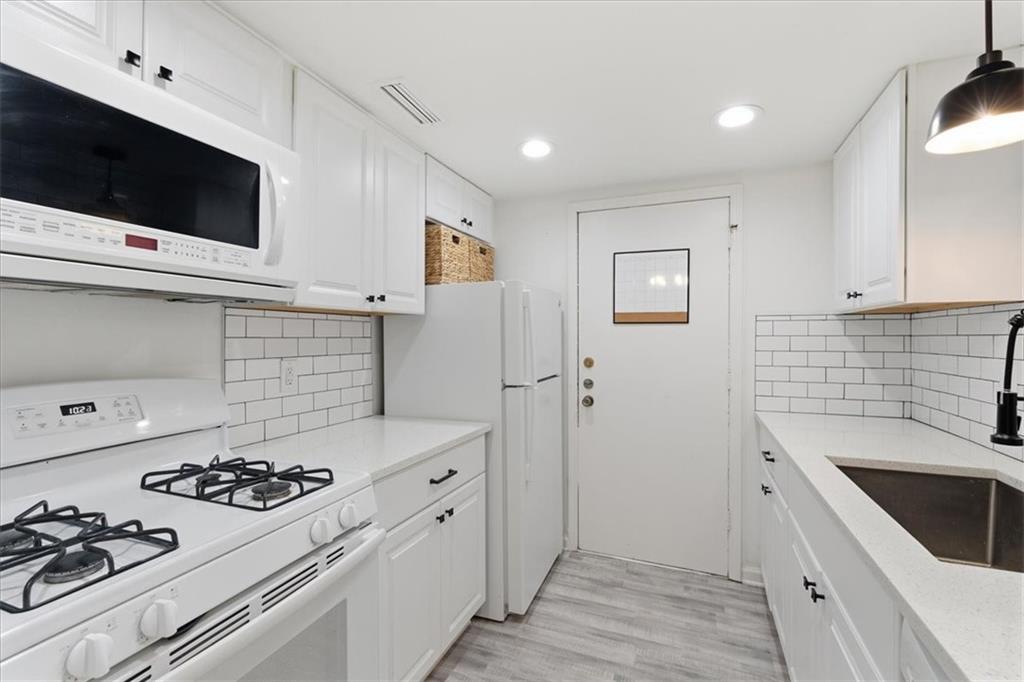 6851 Roswell Road, Unit J14 Sandy Springs, GA 30328 - Photo 5 of 41 a kitchen with a stove and a microwave
