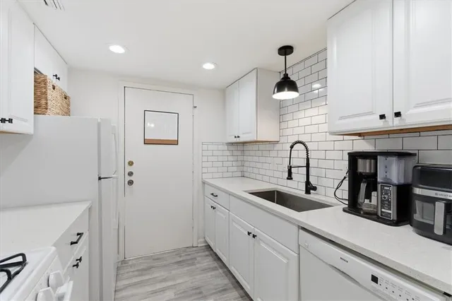 a kitchen with white cabinets and sink