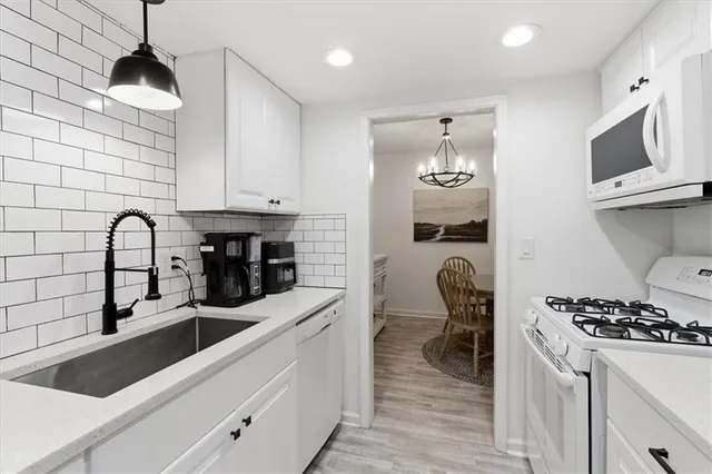 a kitchen with stainless steel appliances a stove a sink a microwave and cabinets