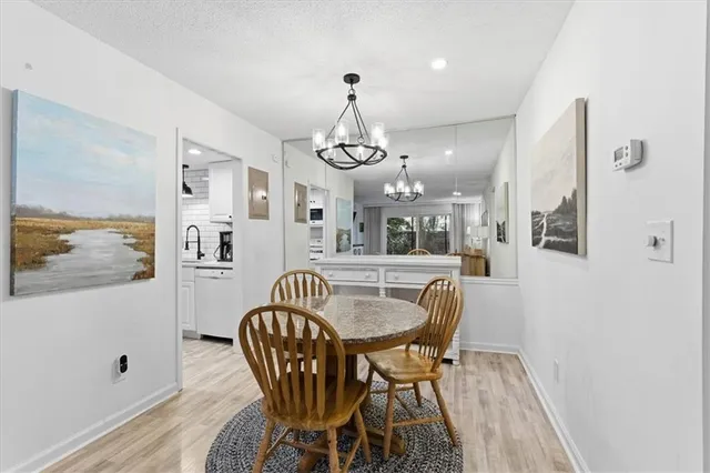 a dining room with furniture a chandelier and wooden floor
