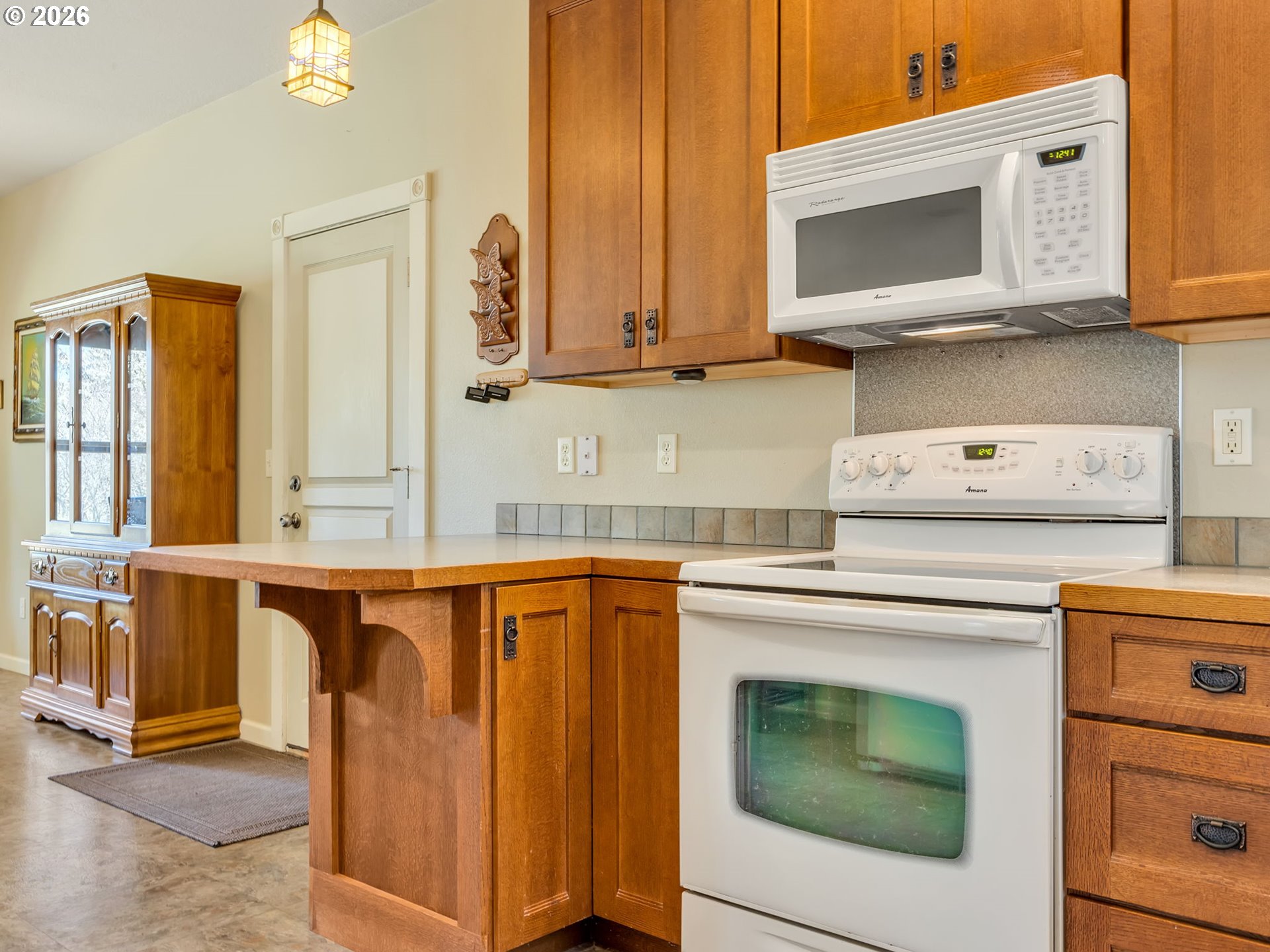 1077 Southwest Ridge Road Warrenton, OR 97146 - Photo 19 of 46 a kitchen with stainless steel appliances granite countertop a stove microwave and cabinets