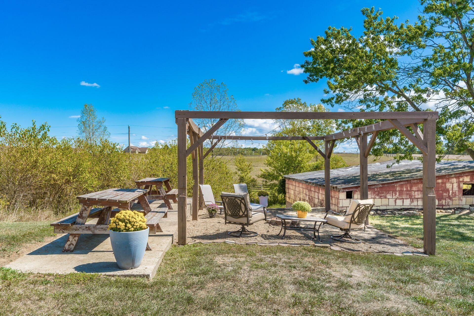 10240 Valentine Road Southwest Stoutsville, OH 43154 - Photo 48 of 60 Pergola area with overhead lighting, firepit, and space for entertaining.