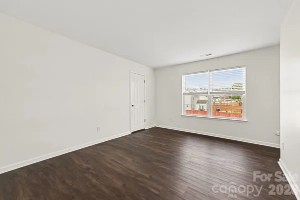 an empty room with wooden floor and window