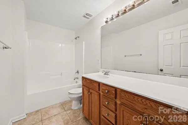 a spacious bathroom with a sink a toilet and a bathtub