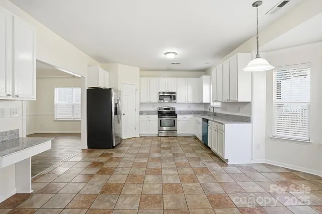 a kitchen with stainless steel appliances granite countertop a refrigerator stove and sink