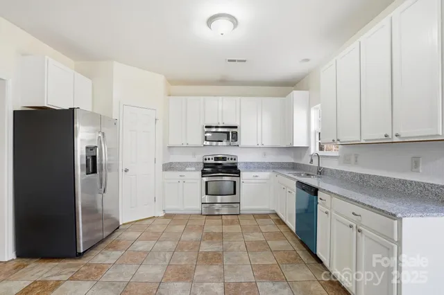 a kitchen with white cabinets stainless steel appliances and sink