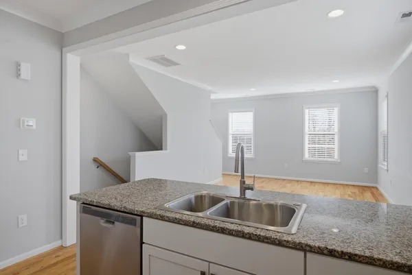 a kitchen with a granite countertop sink and mirror