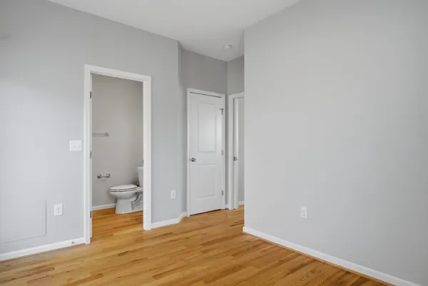 a view of a room with wooden floor and a toilet