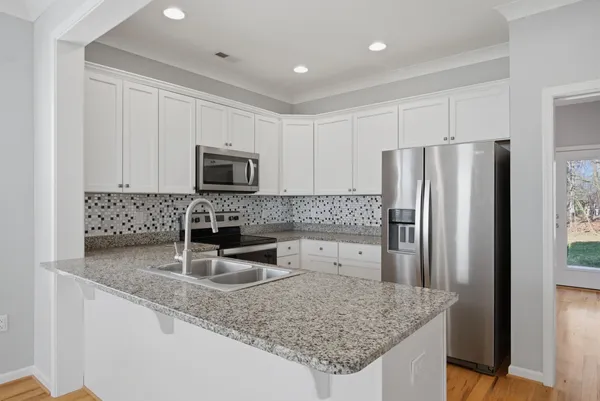 a kitchen with stainless steel appliances granite countertop a refrigerator and a sink