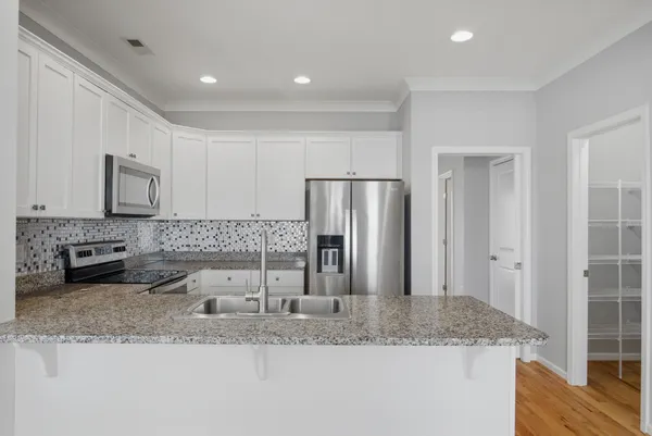 a kitchen with stainless steel appliances granite countertop a sink refrigerator and microwave
