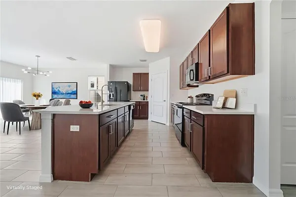 a large kitchen with stainless steel appliances a sink and cabinets