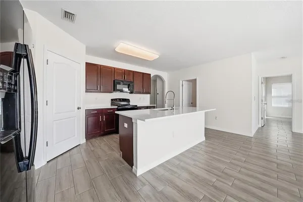 a kitchen with wooden floors and stainless steel appliances