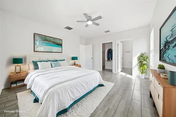 a spacious bedroom with a bed and a potted plant