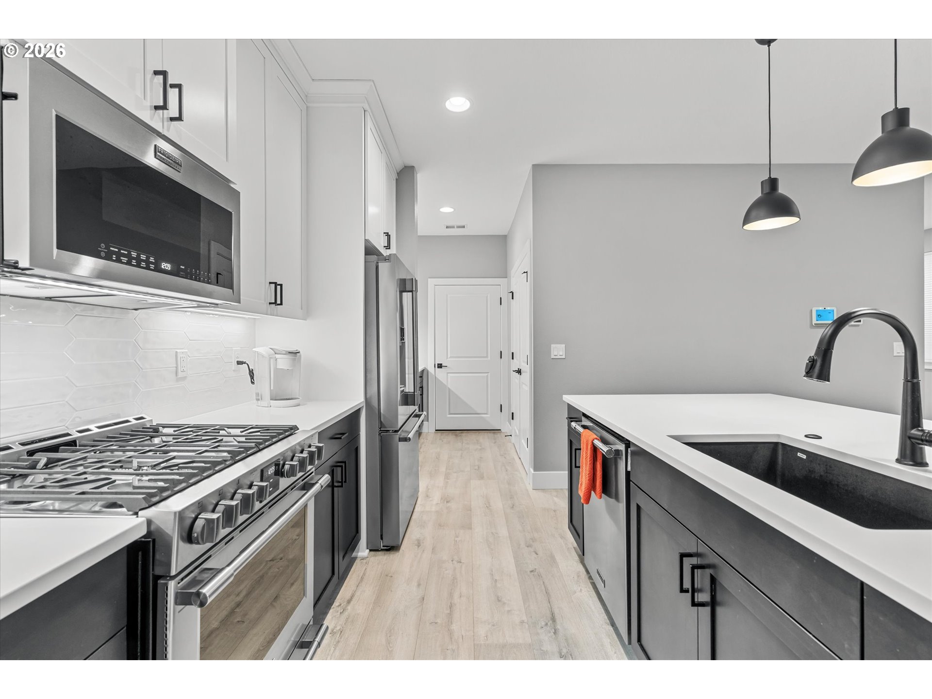723 Southwest 49th Street Gresham, OR 97080 - Photo 13 of 48 a kitchen that has a sink and a stove with wooden floor