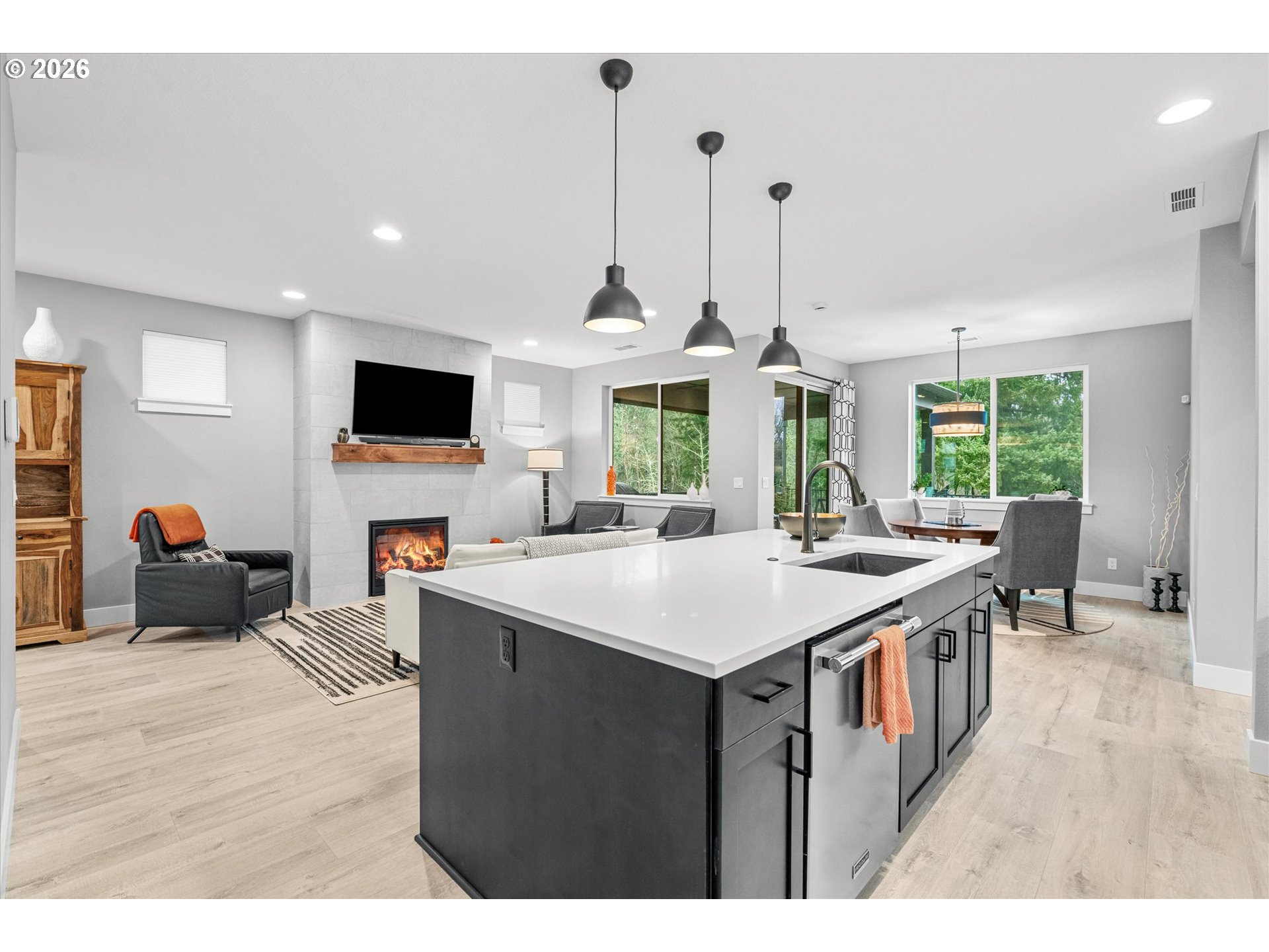 723 Southwest 49th Street Gresham, OR 97080 - Photo 17 of 48 a open kitchen with stainless steel appliances kitchen island a stove a sink dishwasher and a fireplace with wooden floor