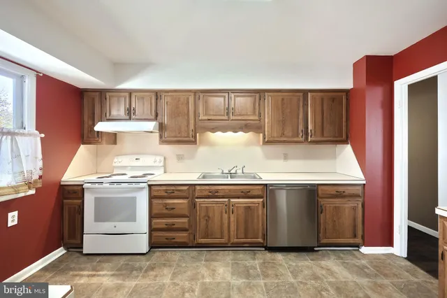 a kitchen with stainless steel appliances granite countertop a refrigerator a sink and a stove