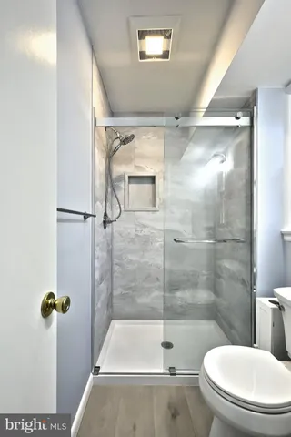 a bathroom with a sink toilet a mirror and shower