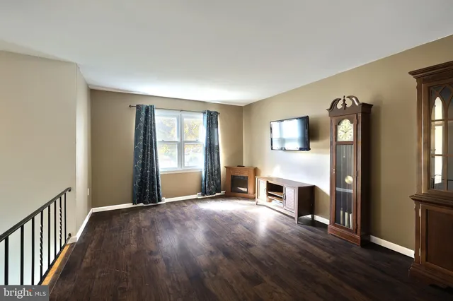 a view of empty room with wooden floor