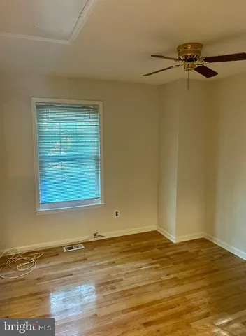 a view of a room with wooden floor and a ceiling fan