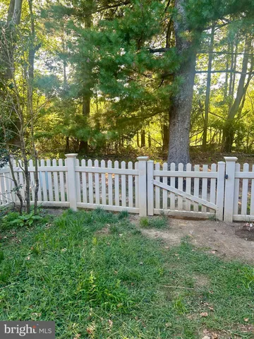 a view of a yard with wooden fence