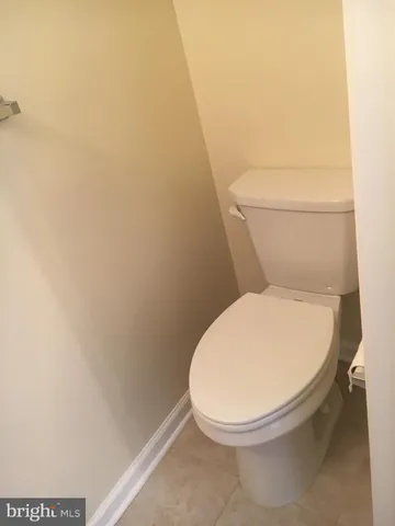 a white toilet sitting next to a white wall