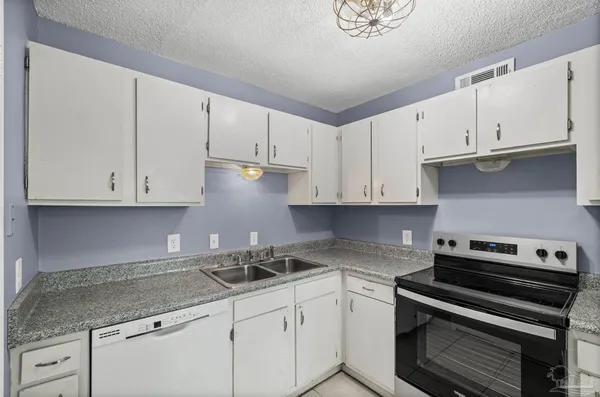 a kitchen with stainless steel appliances granite countertop a sink stove and cabinets